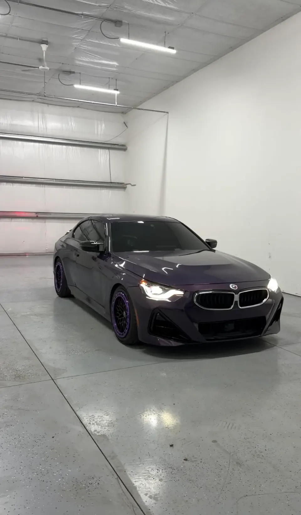 BMW coupe with tinted windows inside the shop